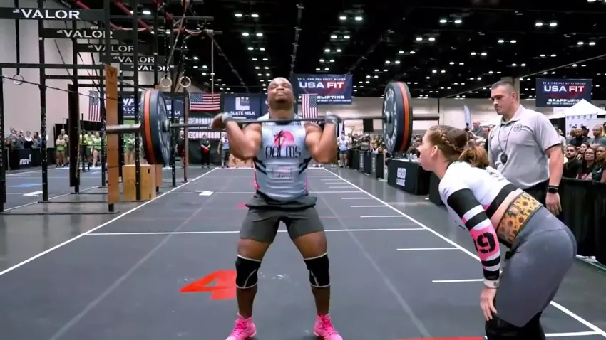 A referee watches an athlete lifting during the championship